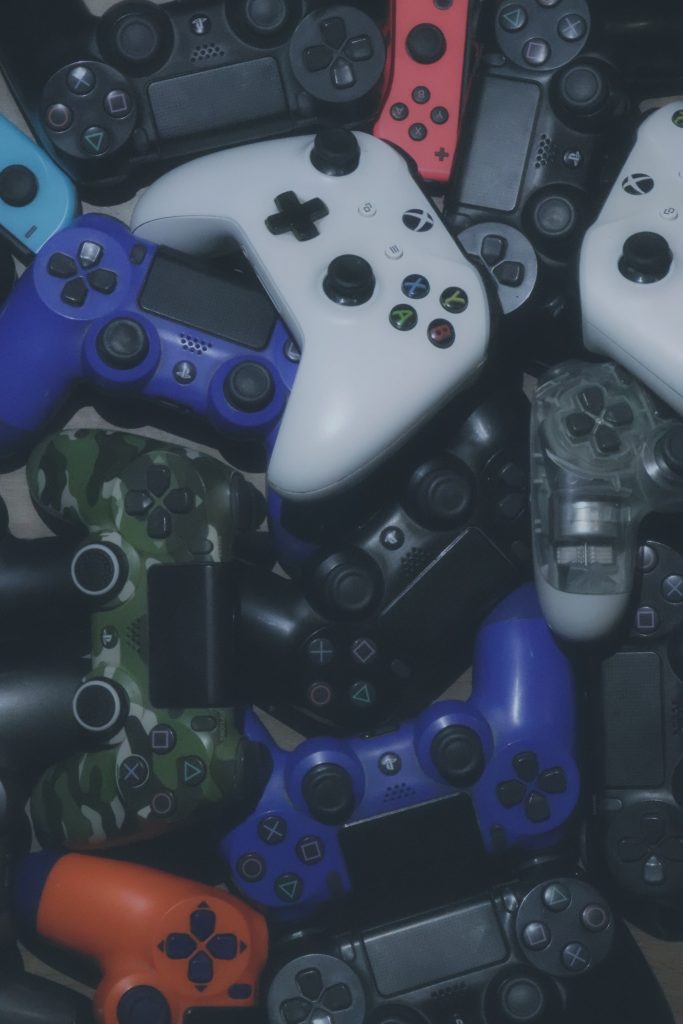 variety of different video game controllers laid out on floor