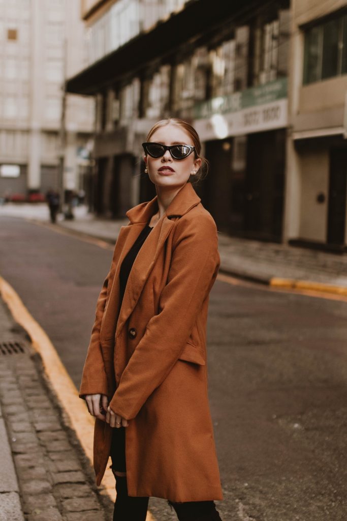 A Woman in a Trench Coat Wearing Sunglasses